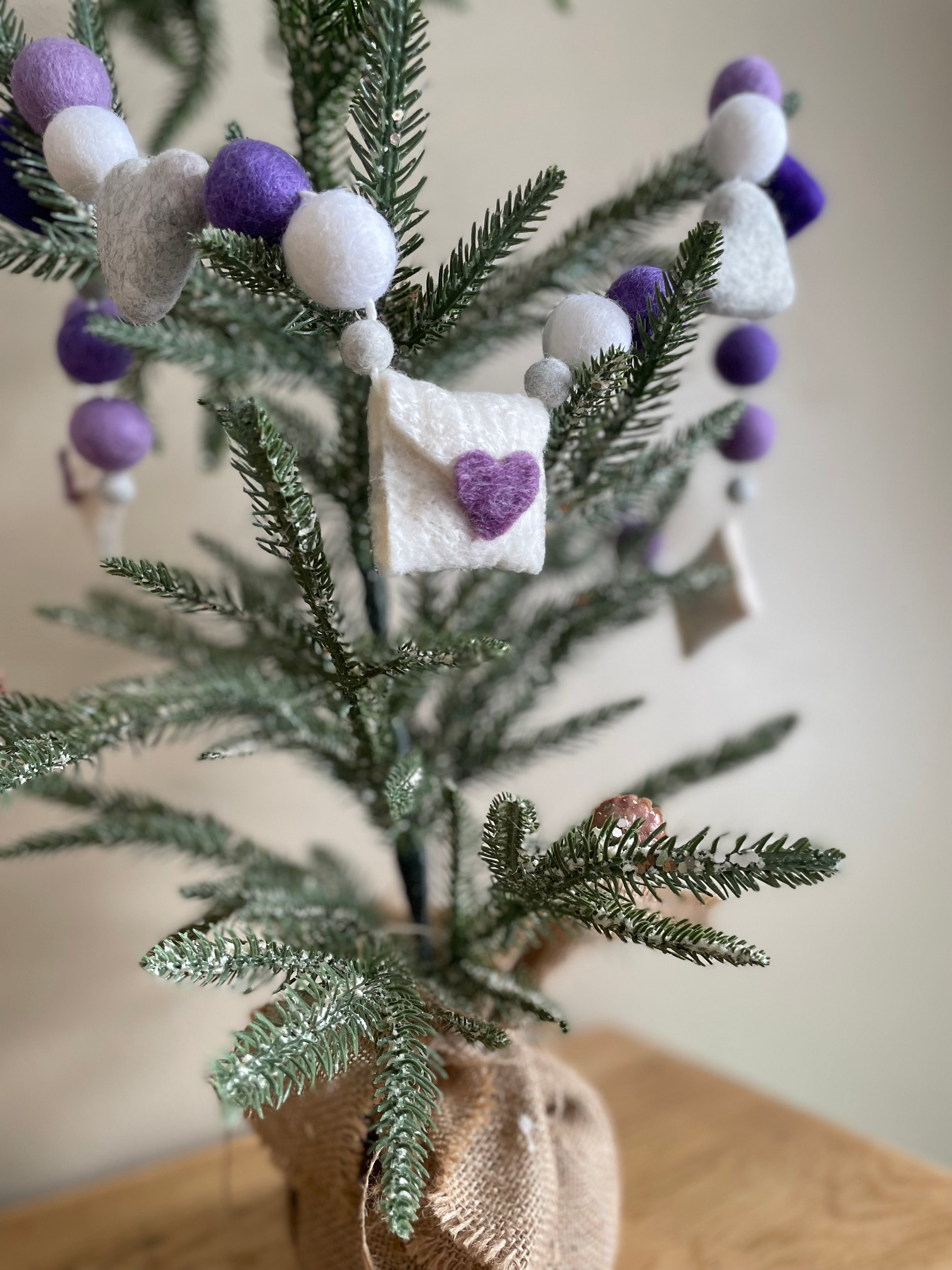 Decorative felt wool garland with purple hearts and love letters for Valentine's day.