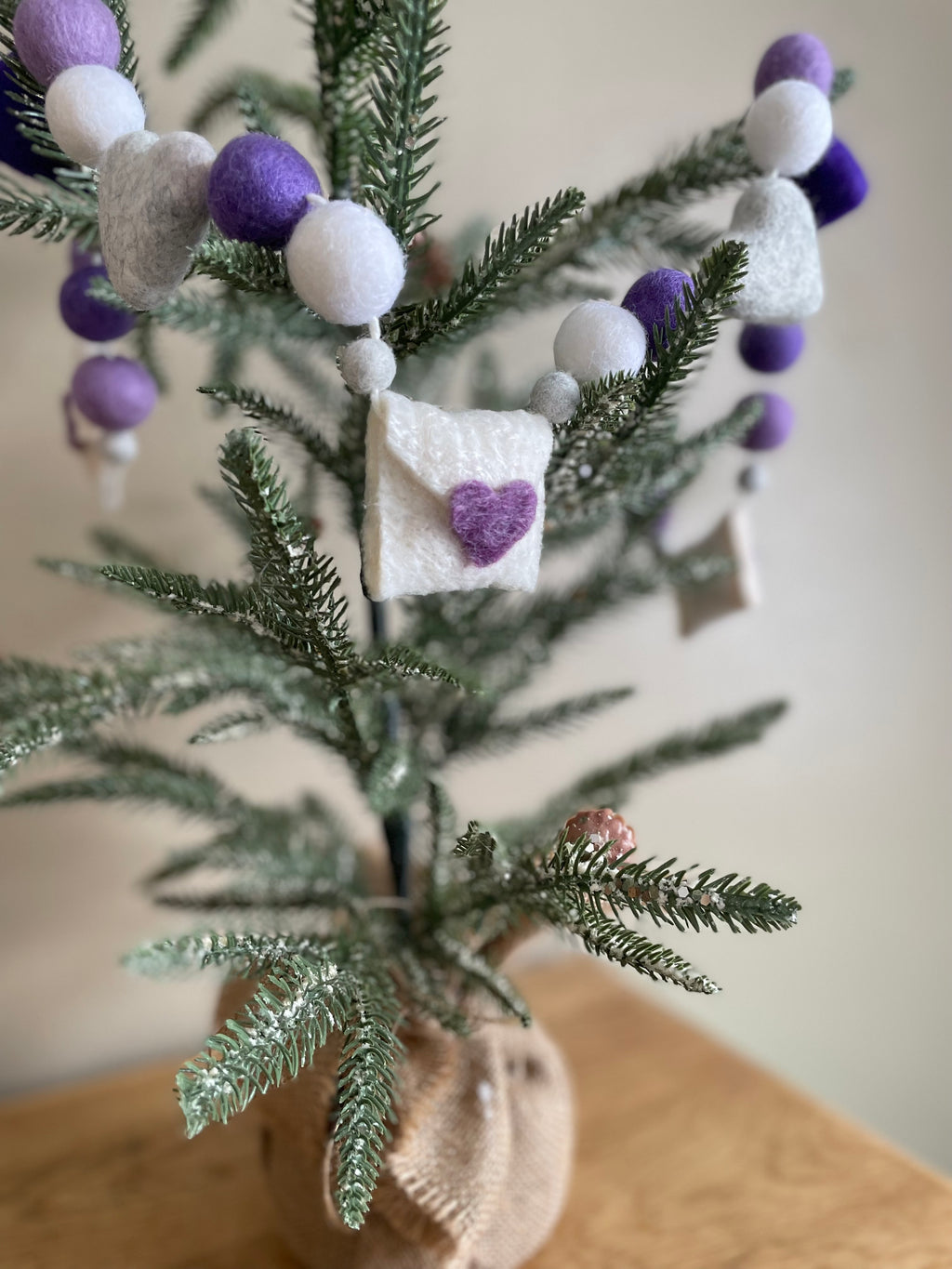 Decorative felt wool garland with purple hearts and love letters for Valentine's day.
