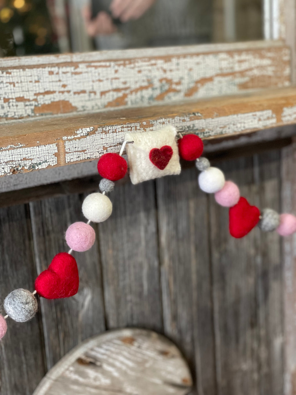 Decorative felt wool garland with red and pink hearts and love letters for Valentine's day.