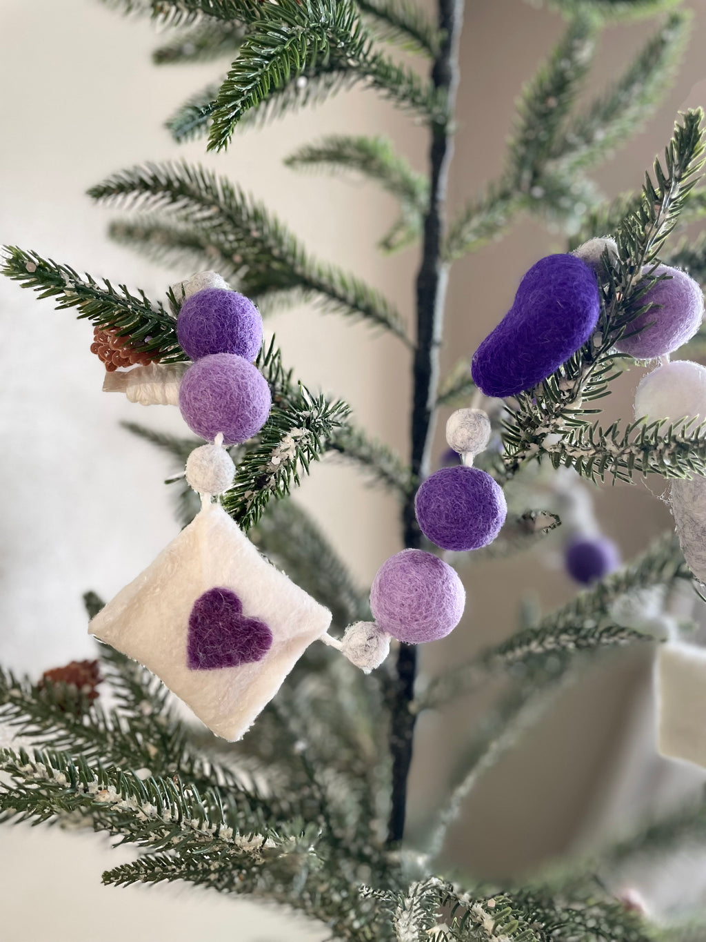Decorative felt wool garland with purple hearts and love letters for Valentine's day.