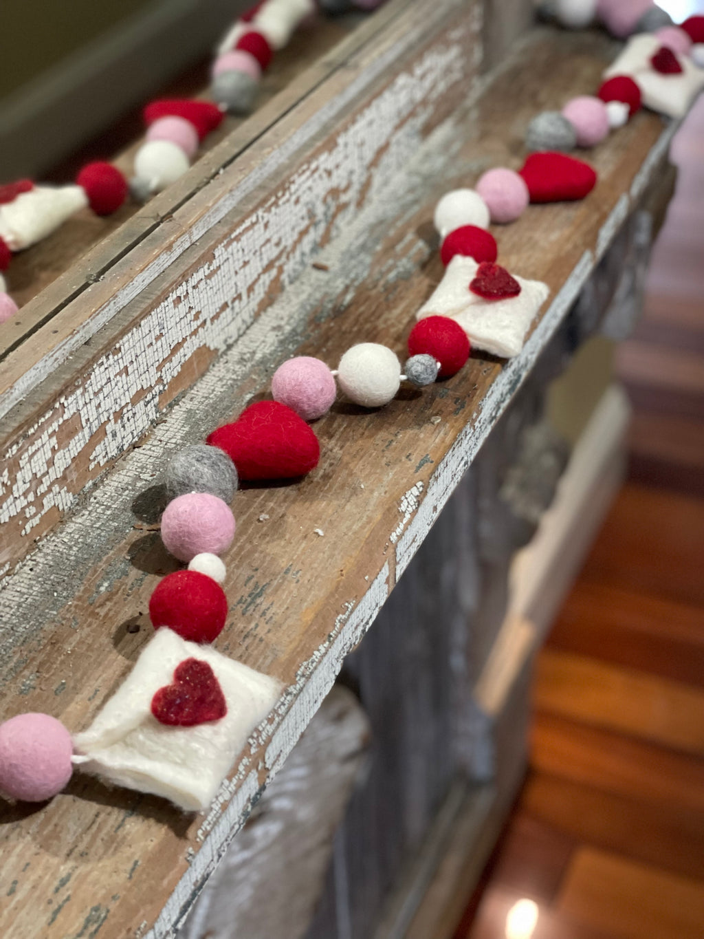 Decorative felt wool garland with red and pink hearts and love letters for Valentine's day.